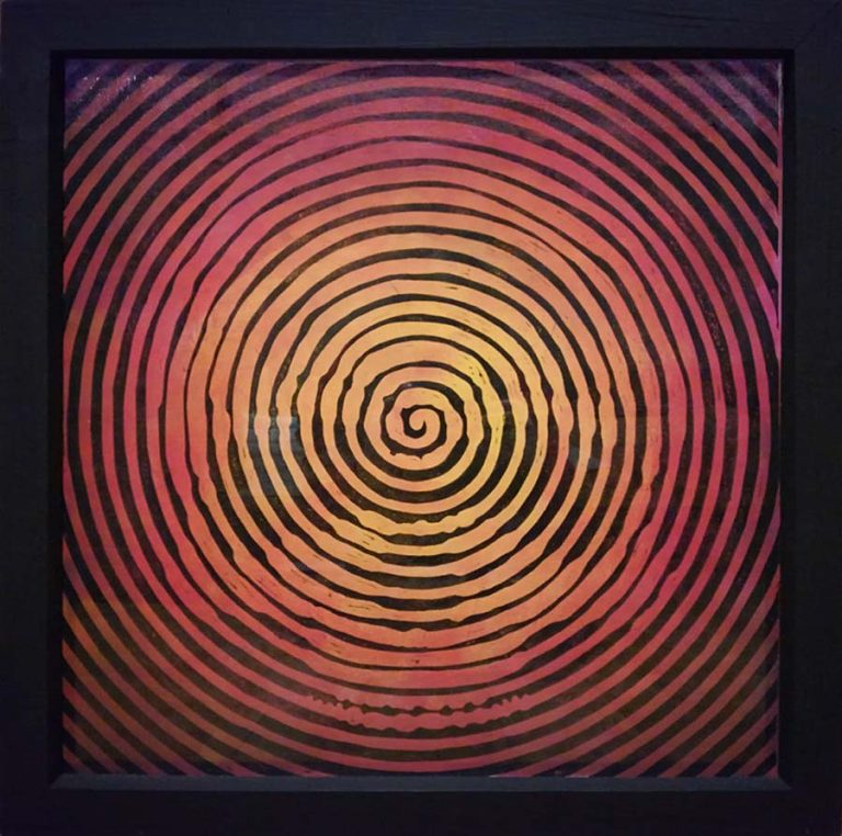 Linocut print of a skull in an orange and black spiral